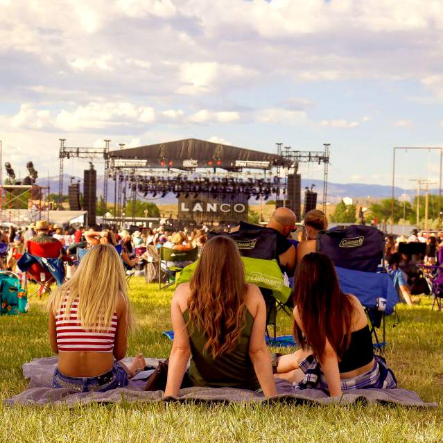 Three Women Sitting and Watching concert at Country Jam Colorado
