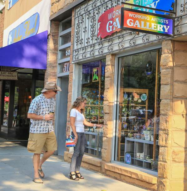 Couple walks down Main Street looking in the windows of local businesses